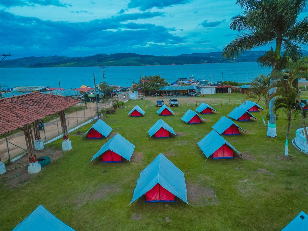 Campamento CAMCOL con carpas a orillas del Lago Calima al atardecer